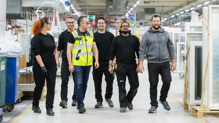 Henkilöitä ryhmäkuvassa Kaskipuun tehtaalla työympäristössä.